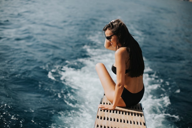 Pretty woman relaxing on the yacht on sea at sunny day