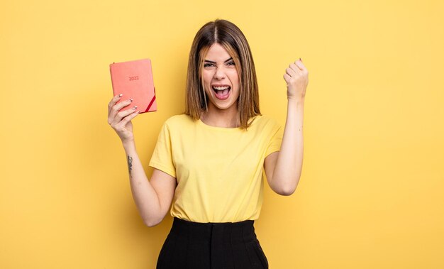 Pretty woman shouting aggressively with an angry expression. planner concept