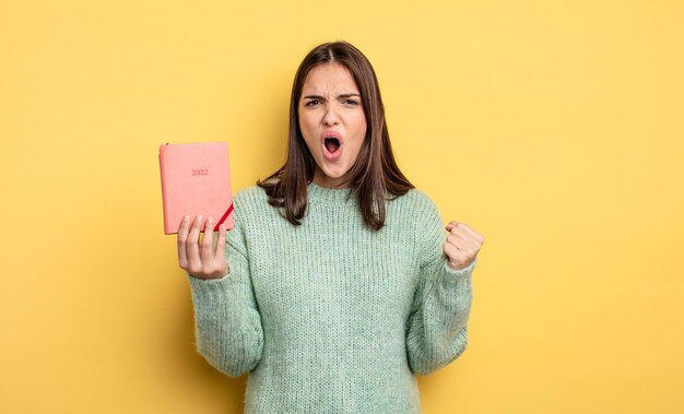 Pretty woman shouting aggressively with an angry expression. planner concept