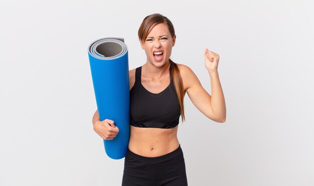 Pretty woman shouting aggressively with an angry expression. yoga concept