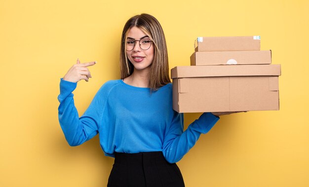 pretty woman smiling confidently pointing to own broad smile packages boxes concept