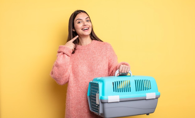 Pretty woman smiling confidently pointing to own broad smile pet carrier concept