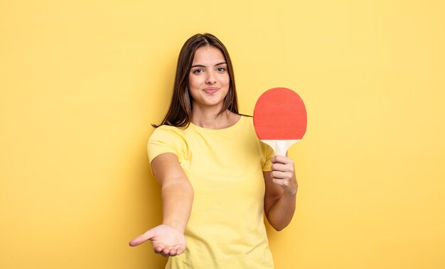 フレンドリーで幸せそうに笑って、コンセプトを提供し、見せてくれるきれいな女性。ピンポンのコンセプト