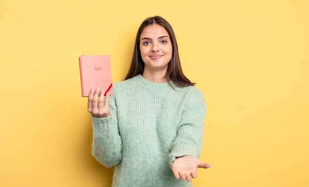 Pretty woman smiling happily with friendly and  offering and showing a concept planner concept