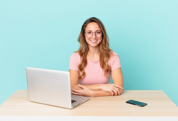 Pretty woman smiling happily with a hand on hip and confident. telework concept