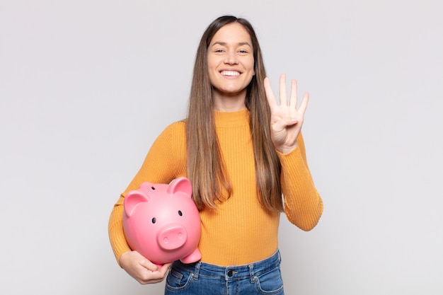 pretty woman  smiling and looking friendly, showing number four or fourth with hand forward, counting down