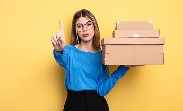 Pretty woman smiling and looking friendly, showing number one packages boxes concept