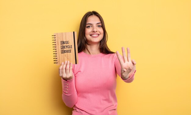 Pretty woman smiling and looking friendly showing number three recycle concept