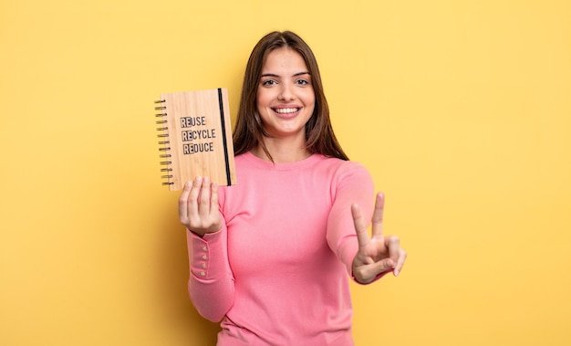 Pretty woman smiling and looking happy, gesturing victory or peace. recycle concept