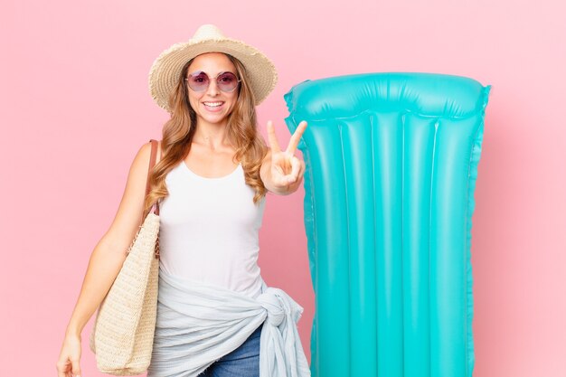 Pretty woman smiling and looking happy, gesturing victory or peace. summer concept