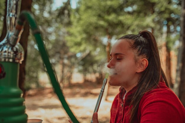 Pretty woman smoking shisha in the forest