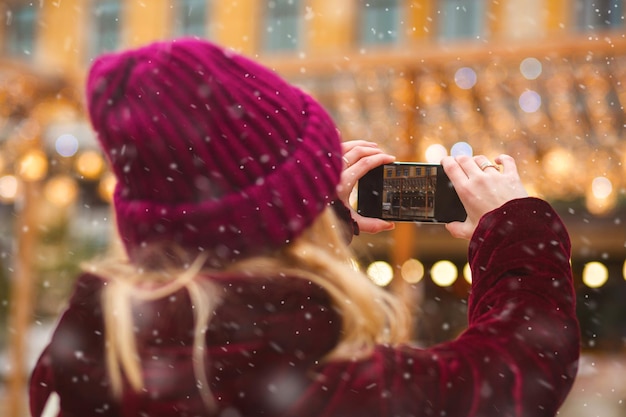 Photo pretty woman taking photo at the holiday fair