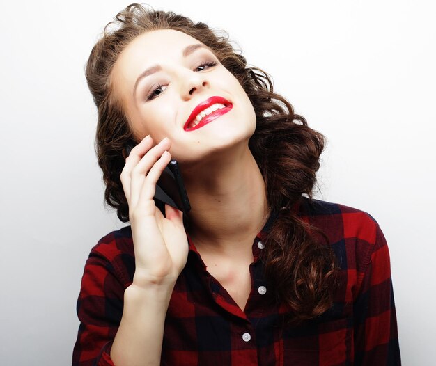 Pretty woman talking on phone over white background