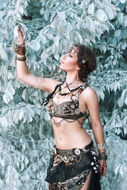 Pretty woman in tribal fusion costume near the beautiful white fairy tree