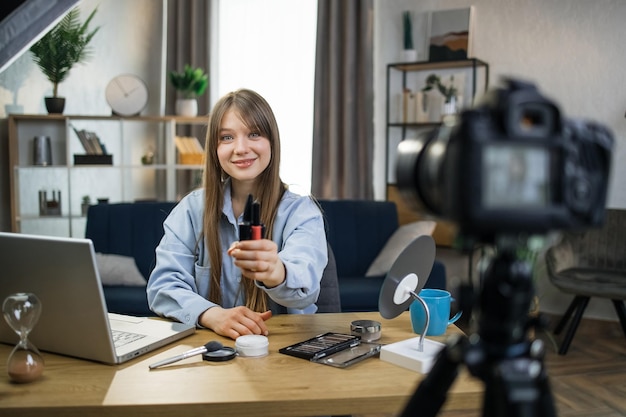 Pretty woman using camera for live streaming about makeup