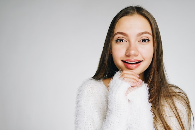 Bella donna in maglione bianco soffice caldo riscalda le mani e sorride