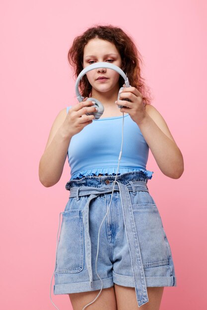 Bella donna che indossa le cuffie distrazione moda danza sfondo rosa inalterato