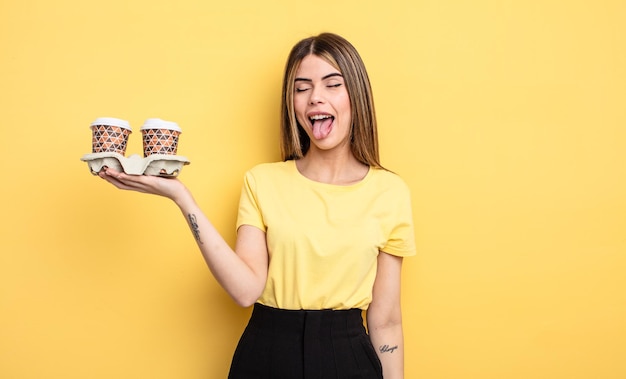 Pretty woman with cheerful and rebellious attitude, joking and sticking tongue out. take away coffees concept