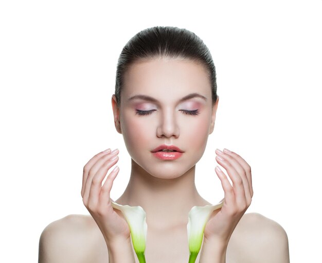 Pretty woman with clear skin and lily flower isolated on white Spa model portrait Skincare and facial treatment concept