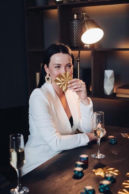 Pretty woman with drink and cards playing poker