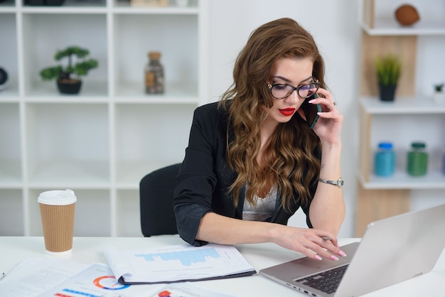 Pretty woman with glasses having a business phone conversation