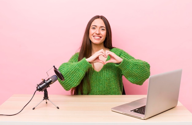 Bella donna con un computer portatile e un microfono concetto freelance di social network