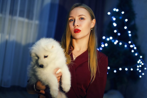 クリスマスの装飾でサモエドハスキー犬ときれいな女性