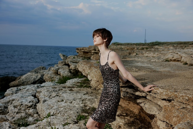 Pretty woman with short hair outdoors stones glamor posing