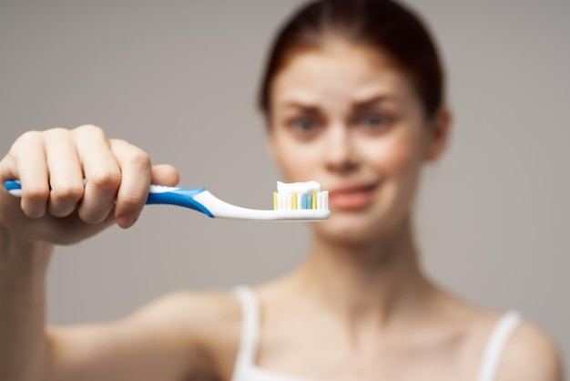 Pretty woman with a toothbrush in hand morning hygiene isolated background