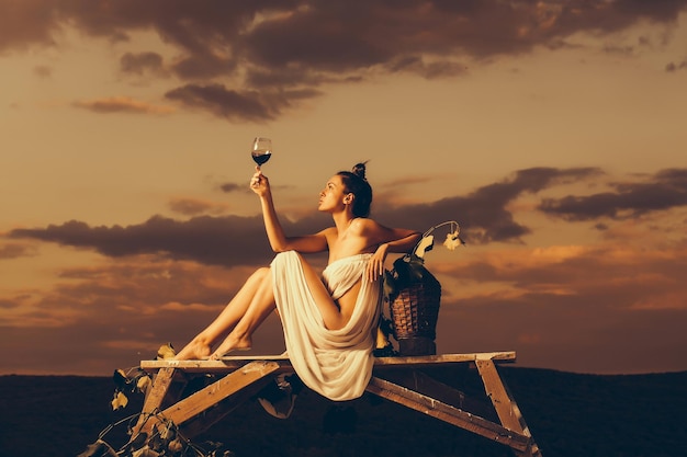 Pretty woman with wine over sky