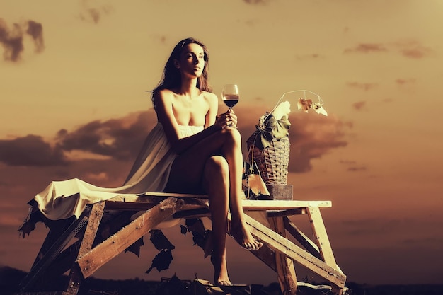 Pretty woman with wine over sky