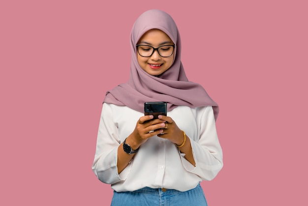 幸せを感じ、スマートフォンを持っているかなり若いアジアの女性