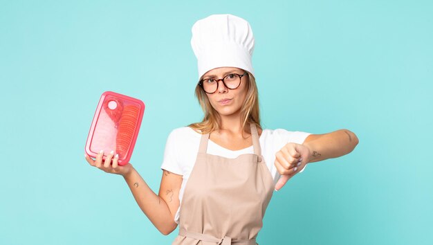 Pretty young blonde chef woman and holding a tupperware