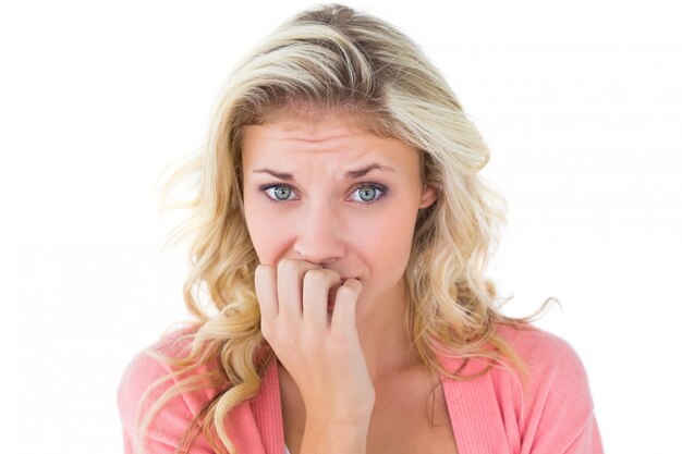 Pretty young blonde feeling nervous on white background