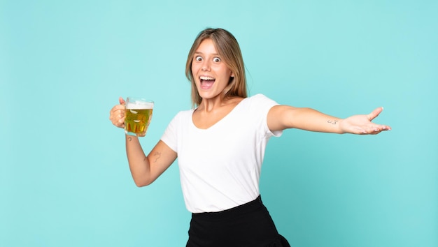 Довольно молодая блондинка женщина держит пинту пива
