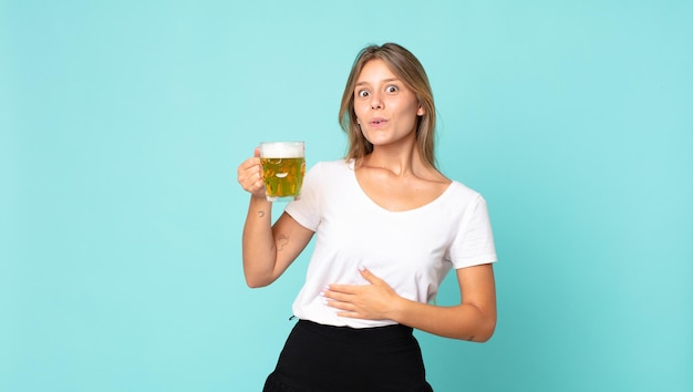 ビールのパイントを保持しているかなり若いブロンドの女性