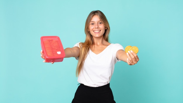 Donna bionda abbastanza giovane che tiene un tupperware