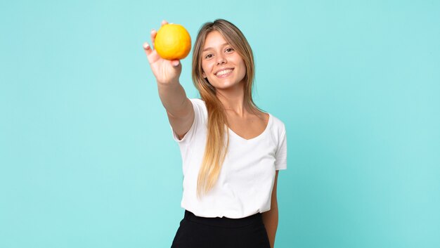 Pretty young blonde woman orange juice concept