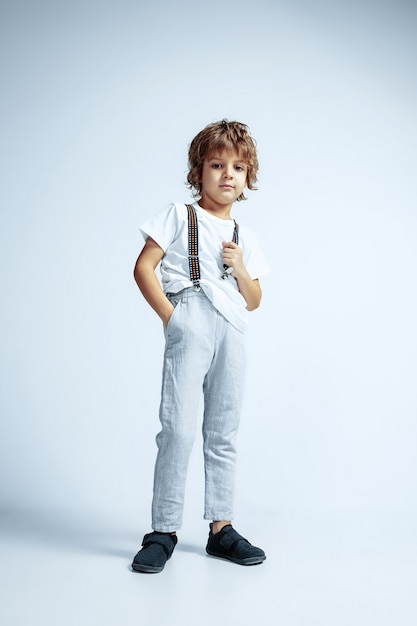 Pretty young boy in casual clothes on white