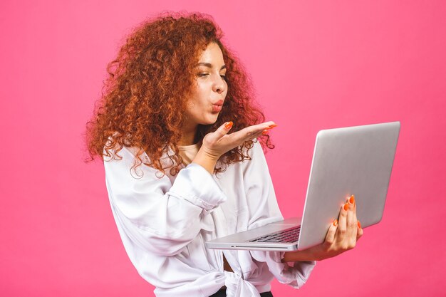 Pretty young business woman in casual holding laptop