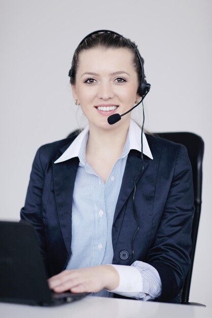 Pretty young business woman group with headphones smiling at you against white background