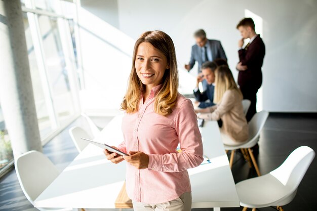 Pretty young business woman using digital tablet in the office