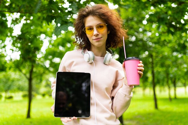 Pretty young caucasian woman is engaged in freelance in the park