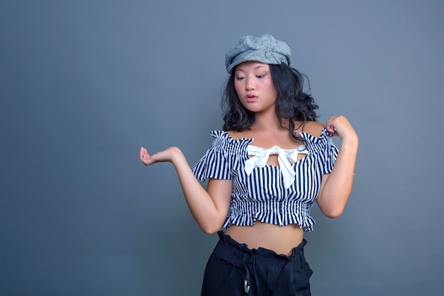 Pretty young Chinese girl posing for the camera on a gray background