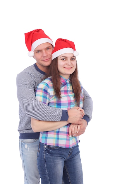 Pretty young couple wearing Santa Claus caps