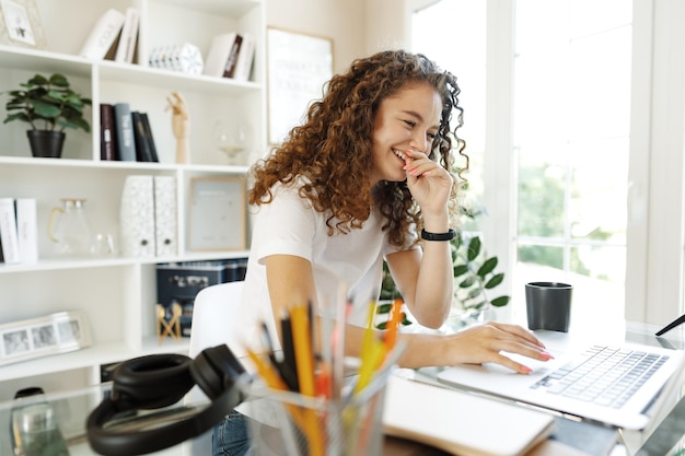 Pretty young entrepreneur woman working with laptop sitting in the office