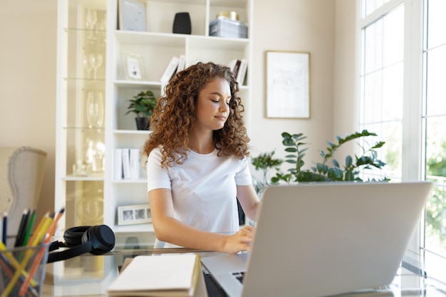 Donna abbastanza giovane dell'imprenditore che lavora con il computer portatile che si siede nell'ufficio