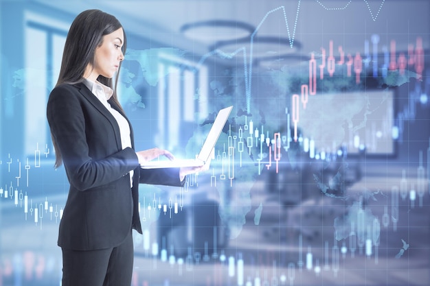 Photo pretty young european businesswoman with laptop standing in blurry office interior with forex chart trade and stock market concept double exposure