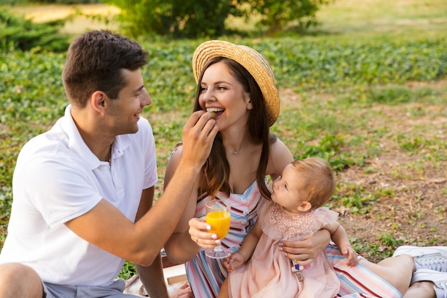 Pretty young family with little baby girl spending time together