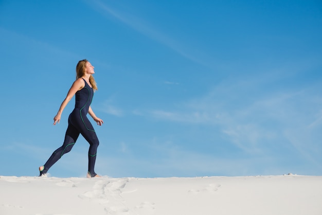 Pretty young female jogging in the desert